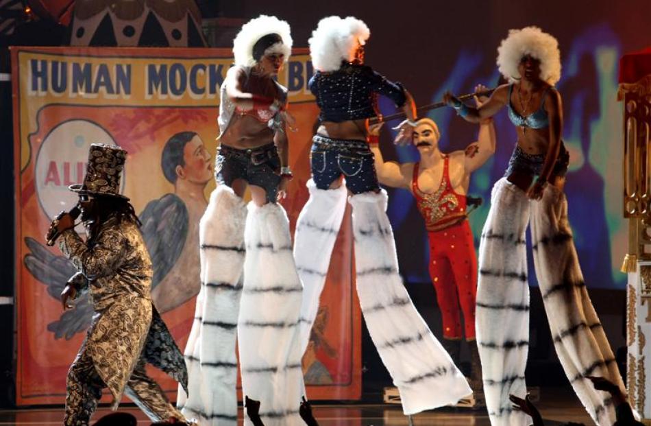 T-Pain, bottom left, performs with stilt-walkers. (AP Photo/Hector Mata)