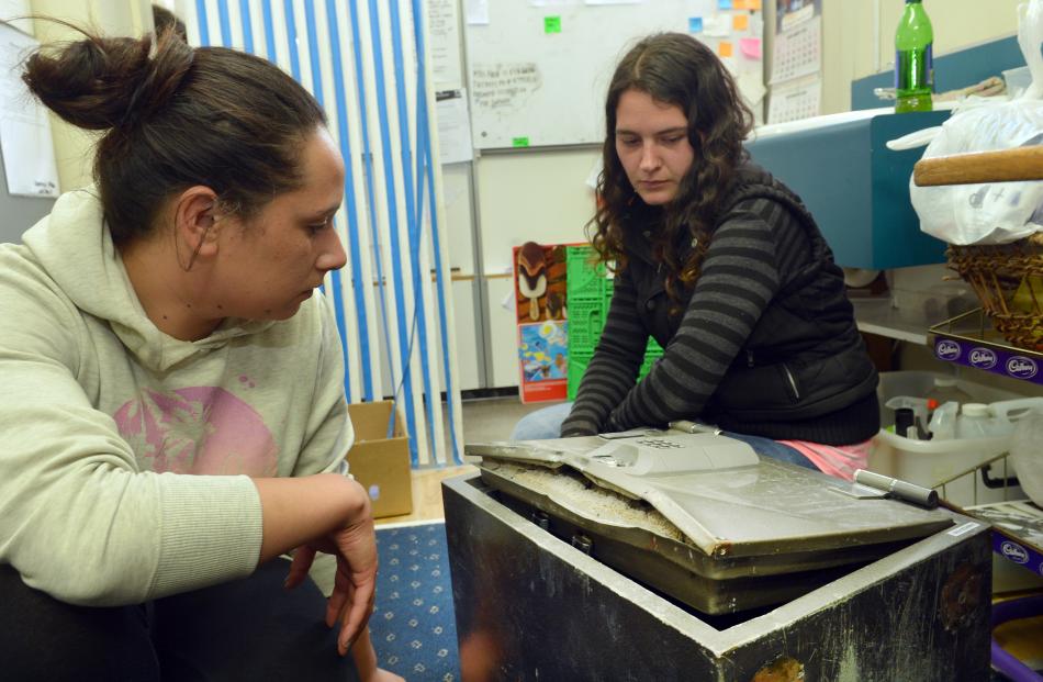 Grocery King staff members Connie Tapuni (left) and Ashlee Gibbs inspect a safe cracked during an...