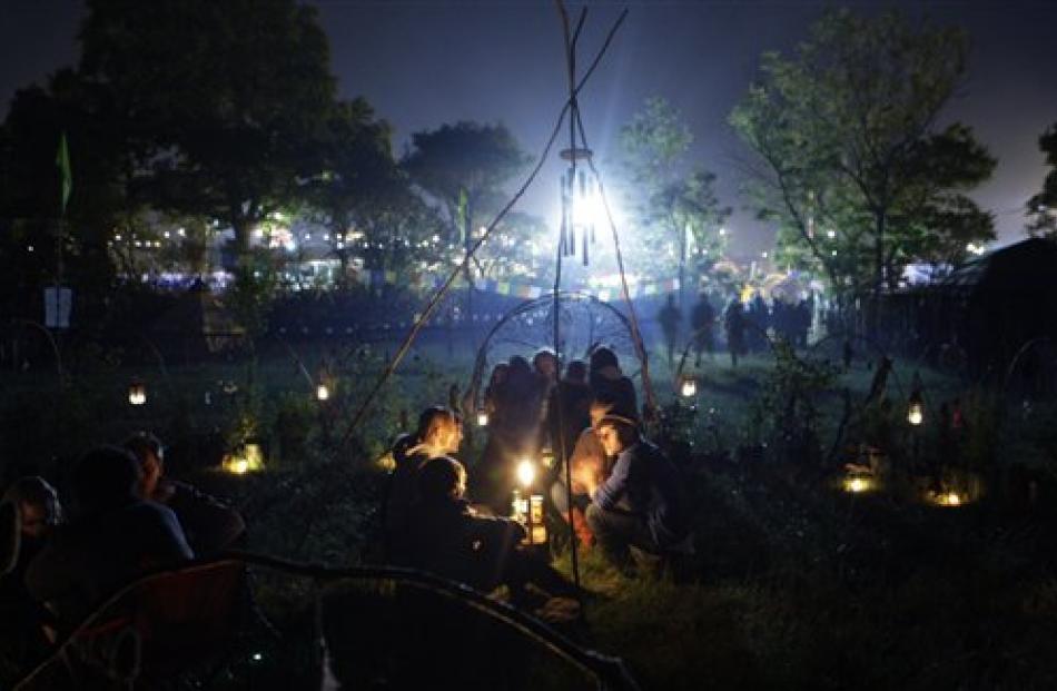 Festival campers sit by a candle.