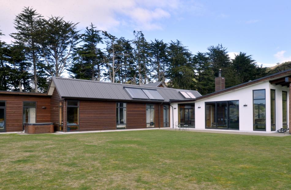 The living spaces open up to the north while the cedar-clad bedroom wing has an east-west...