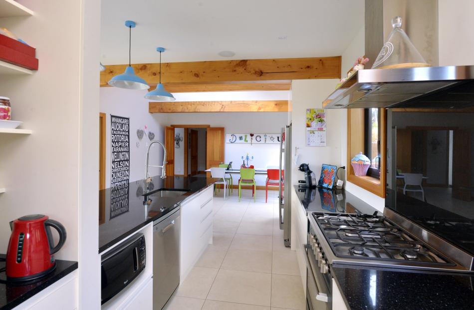 The streamlined kitchen has black granite bench tops and a nook (at left) for the kettle, toaster...