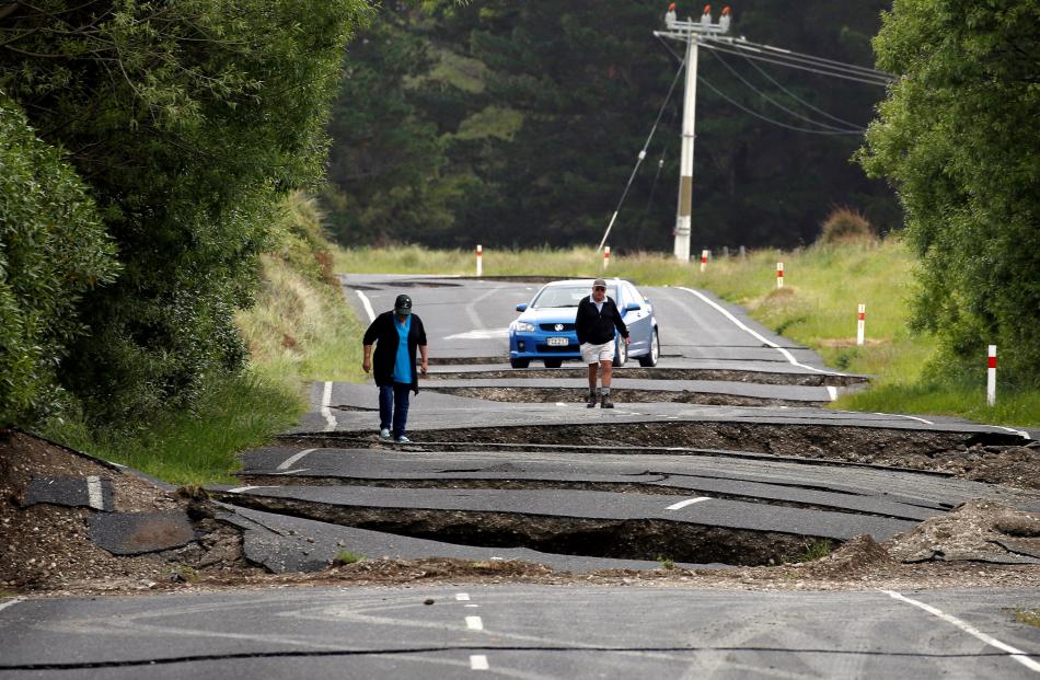 Local residents Chris and Viv Young look at damage caused by an earthquake along State Highway...