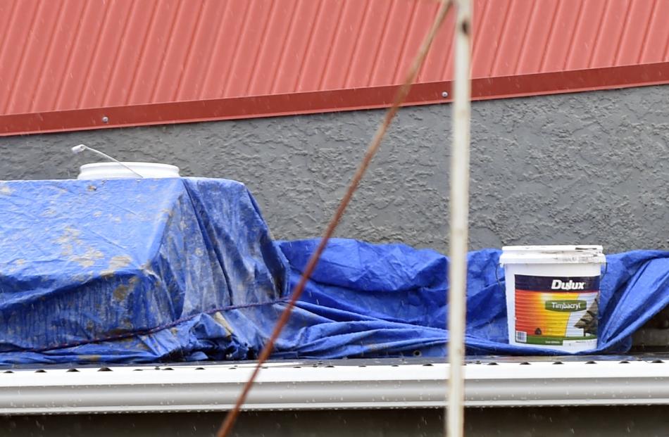 Paint cans are used to hold down a tarpaulin on top of a leaky Aurora Energy substation in...