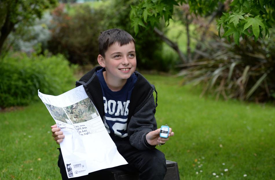 Waitati School pupil Max Port holds a GPS tracking collar and a poster showing the 200ha radius in which his cat, Puss Puss, roamed around his Karitane house. Photos by Linda Robertson.