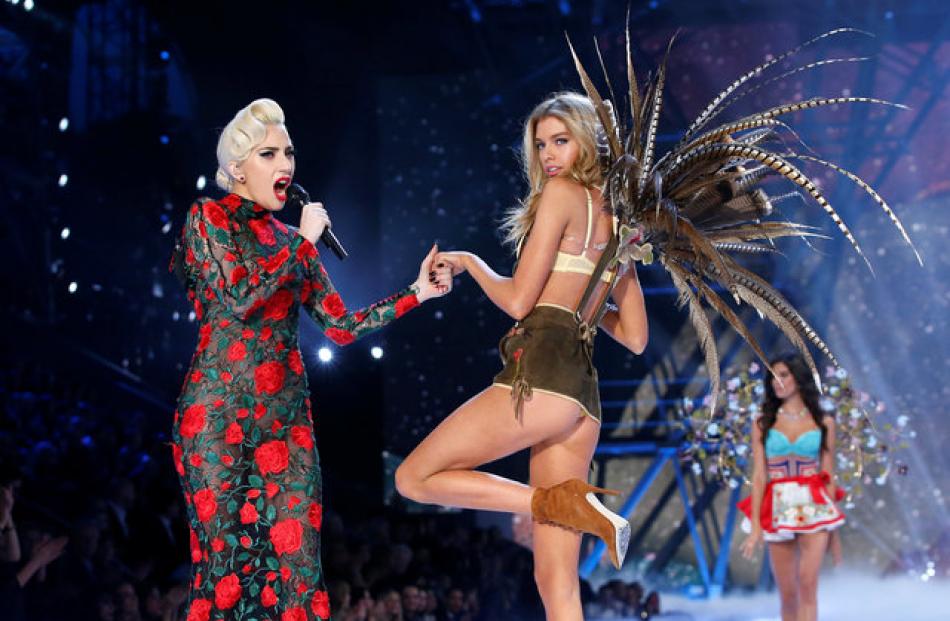 Victoria's Secret model Stella Maxwell struts on the catwalk with popstar Lady Gaga at the...