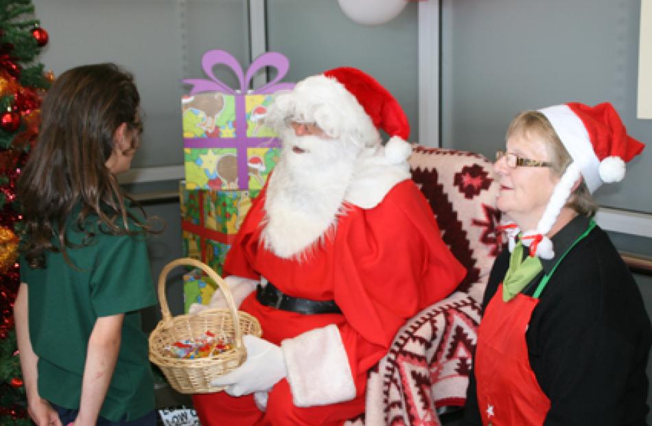 IMG 6507: Father Christmas and Santa’s helper Dot McKay of Fresh Choice hand out the lollies at...