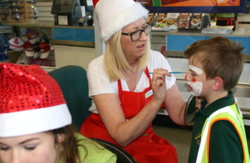 IMG 6508: 5 year old Harry Cavangh has his face painting designed by Fresh Choice Te Anau owner...