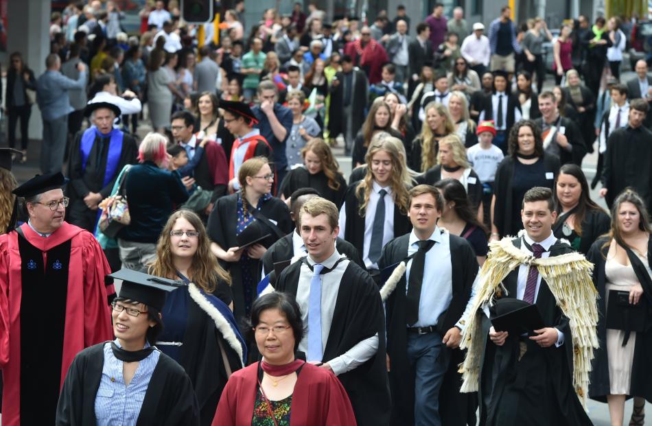 A colourful crowd of graduands marches along George St, Dunedin, on Saturday morning.