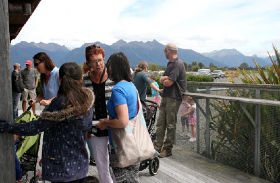 People gather outside the Te Anau Airport terminal in Manapouri awaiting their flights at the...