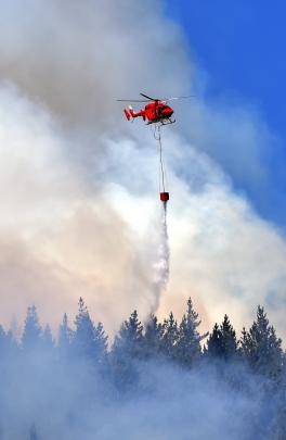 One of five helicopters to be deployed empties a moonson bucket on the fire. Photo by Peter McIntosh.