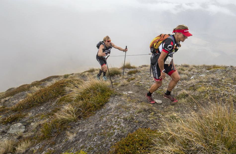 Whoever feels strongest during a race takes the front of the tow line —  in this case it is Maier, helping  Hagener climb a peak. Photo by Graeme Murray/Red Bull Content Pool.