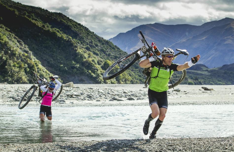 Marcel Hagener leads the way across a river, as he and his partner Simone Maier compete in a mountain bike section of a multi-sport race. 