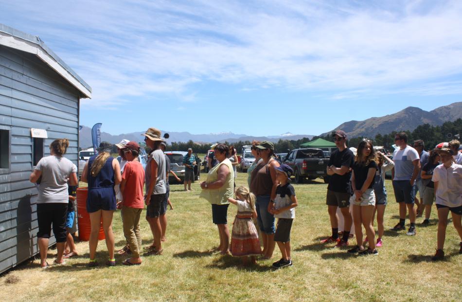People line up at a collection booth to pick up their winnings at the Lake Hawea Picnic Racing Club race meeting. Photos by Tim Miller.