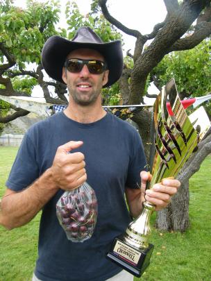 Dave Kowalewski, of Wyndham, holds his trophy for winning the men’s category and overall first...