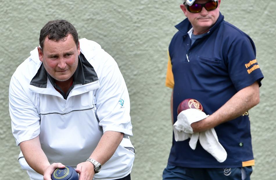 Graeme Hislop (left,  South Otago),  watched by Rodney Fleming (Forbury Park),  prepares to  play a bowl during the final of the Festival Fours in Dunedin yesterday. Hislop was a key figure in South Otago’s win. Photos by Peter McIntosh.