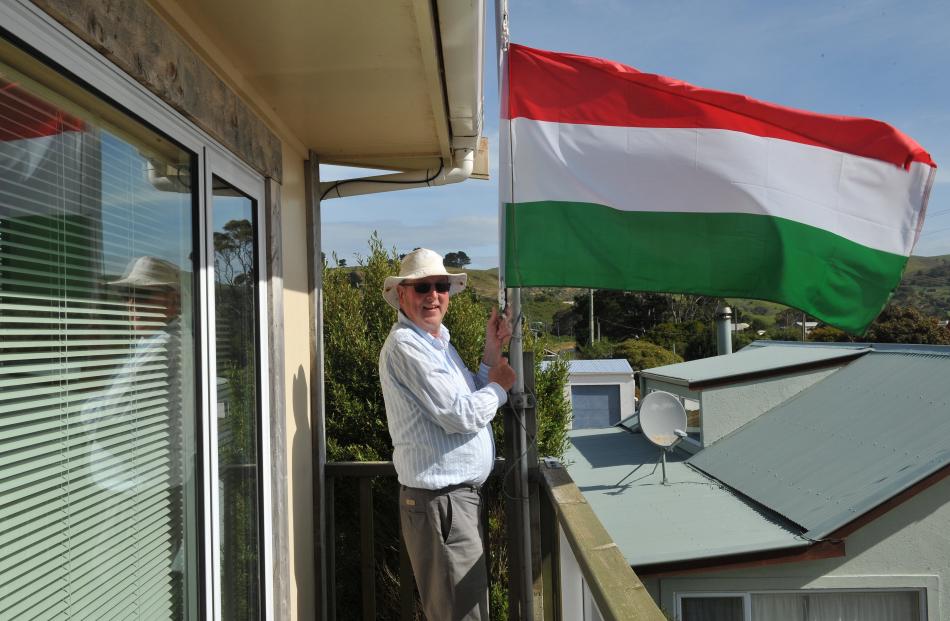 Clark McLean lowers the flag of Hungary at his Harington Point house. Photos: Christine O'Connor.