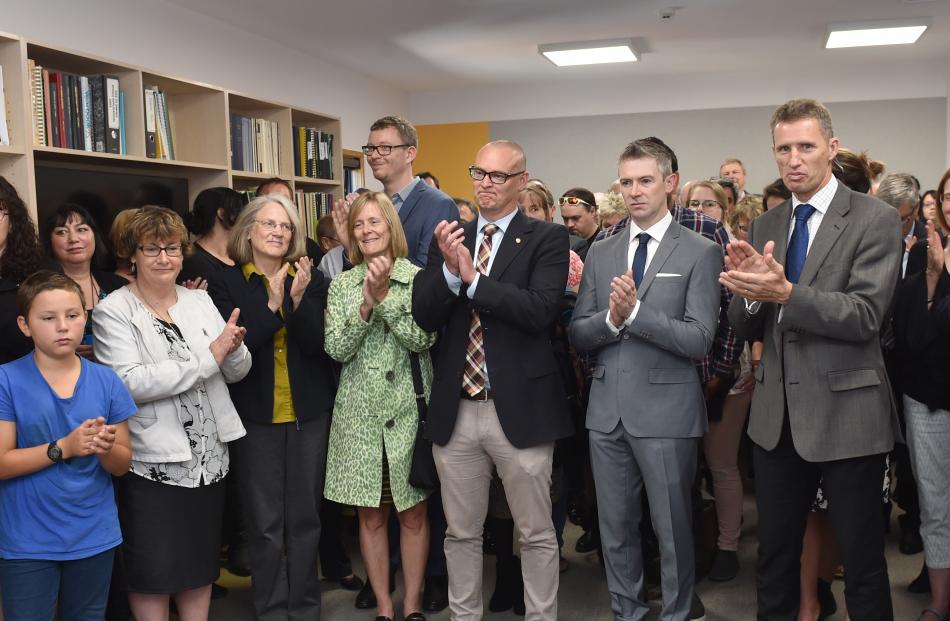 People applaud at the opening of the new building.