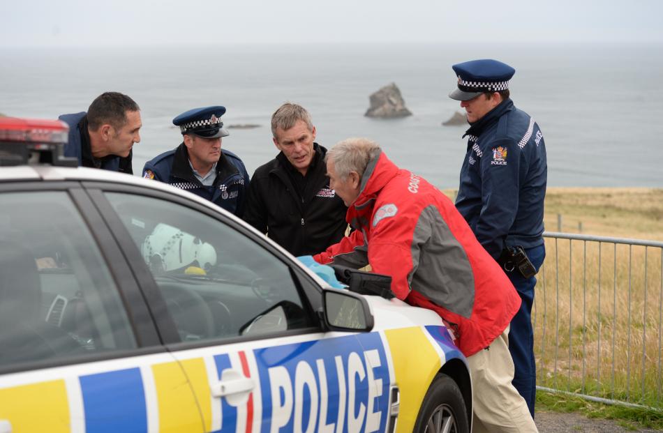 Police and search and rescue personnel plan a search for a missing diver from the Sandfly Bay car...