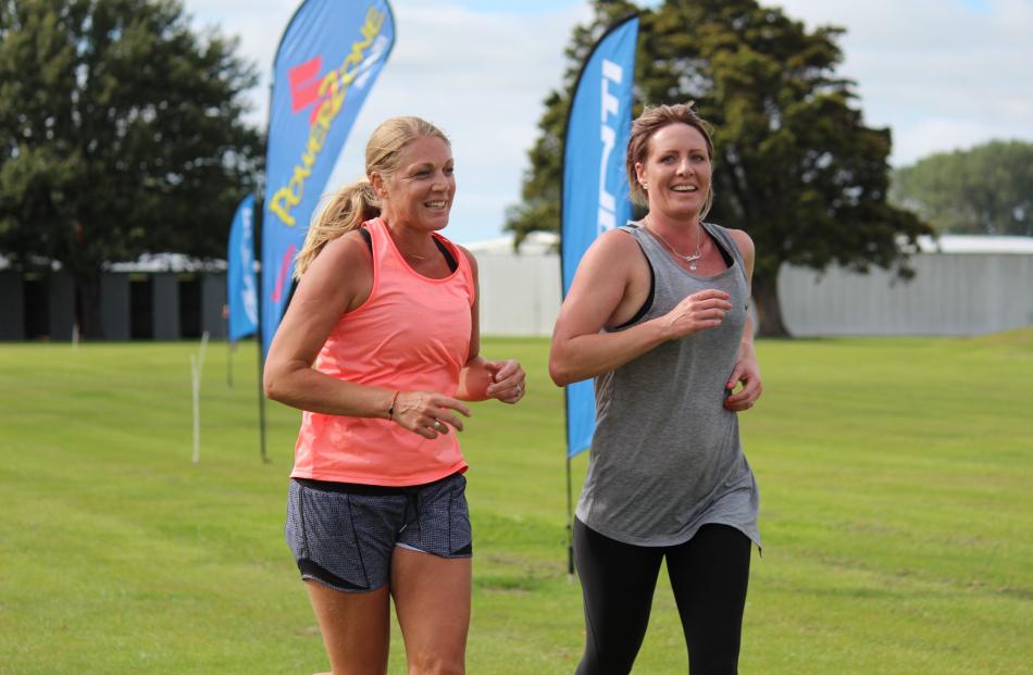 Jackie Ollerenshaw (left) and Anna Milne cross the finish line of the Ken Milne Classic event in...