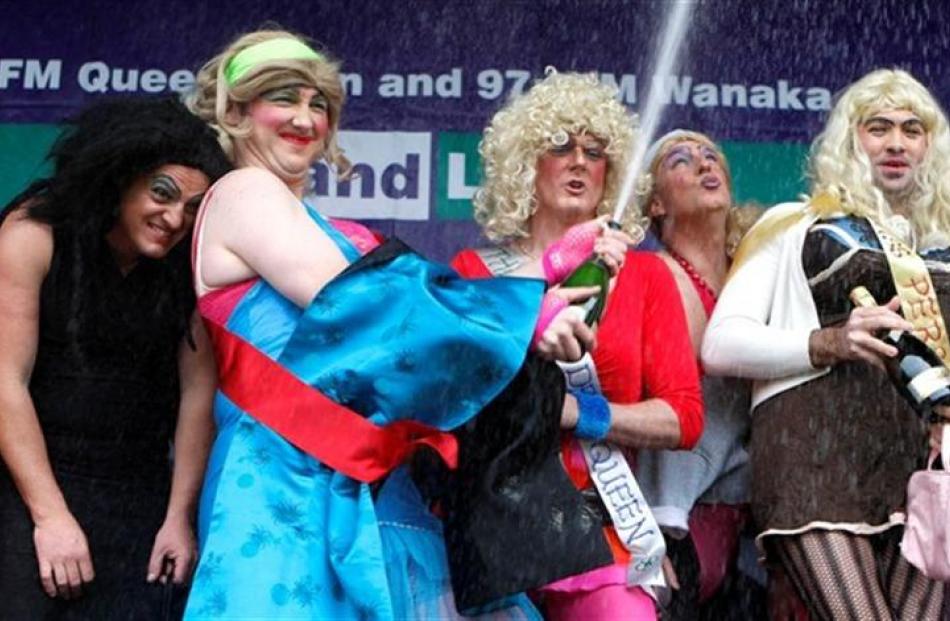 Kane Webster (left) shelters as Miss Photogenic winner Richard Thomas showers the bubbly. The...