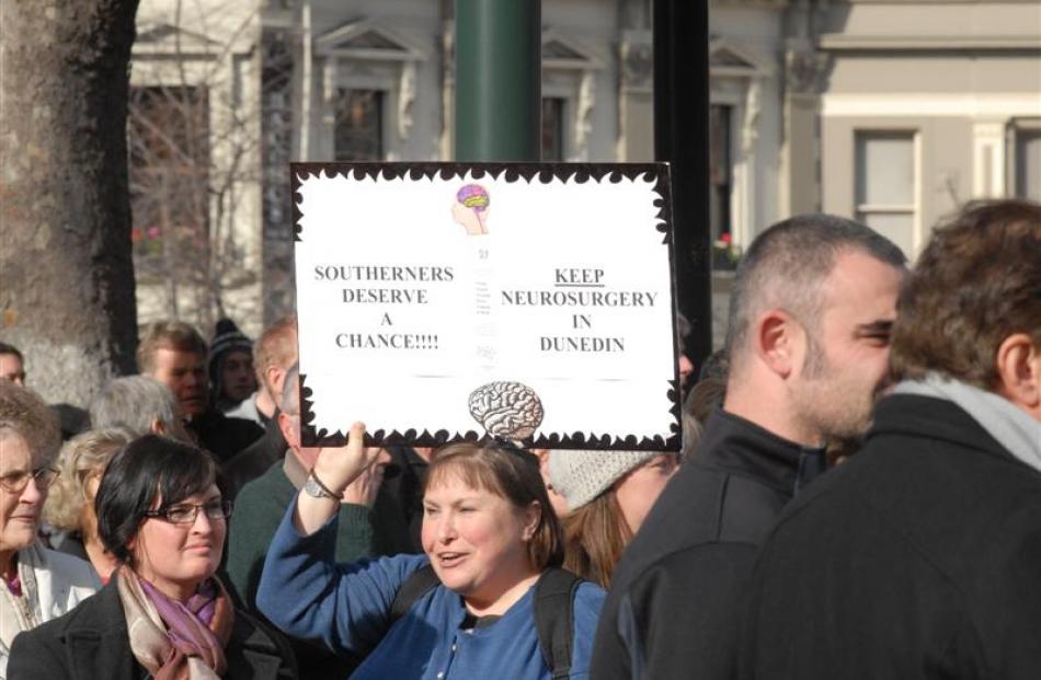 A marcher holds up a protest sign. Photo by Gregor Richardson.