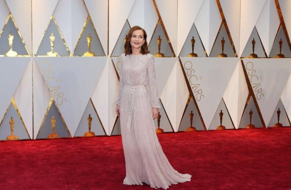 Isabelle Huppert, nominated for Elle showed her typically refined style in a long-sleeved silver Armani Prive gown. Photo: Reuters