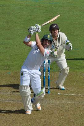 Elgar plays down the ground to the boundary as New Zealand wicketkeeper BJ Watling looks on.