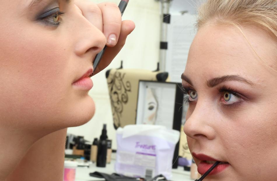 Make-up artist Izzy Ellis applies make-up to model Izzy  Geytenbeek (15) before the runway show...