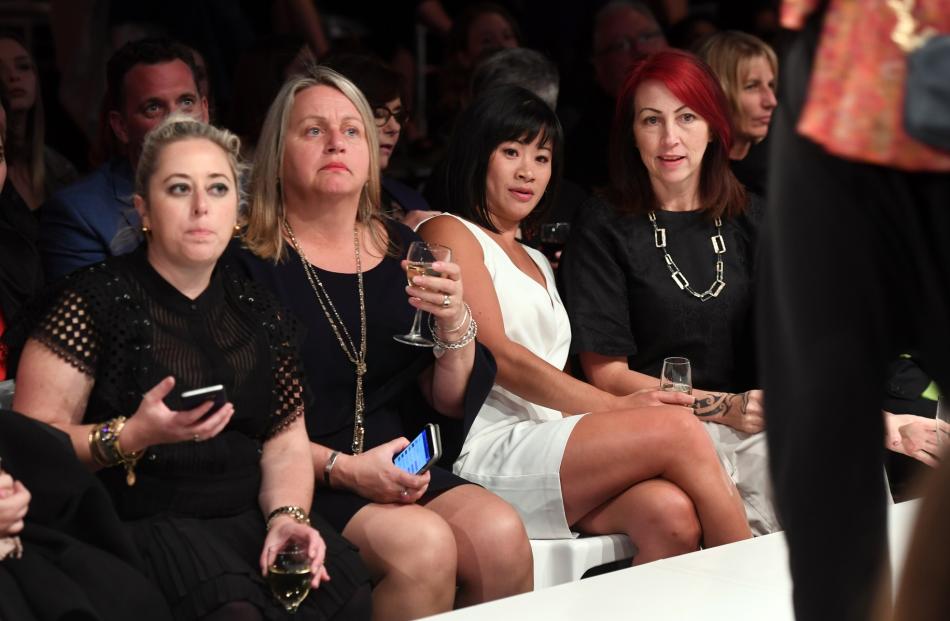 Fashion show attendees cast a critical eye over the designs.