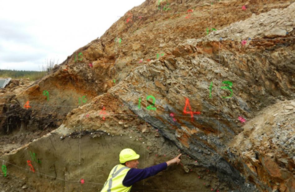 Prof Mark Stirling points at the Akatore Fault, near Dunedin. Photo: supplied.