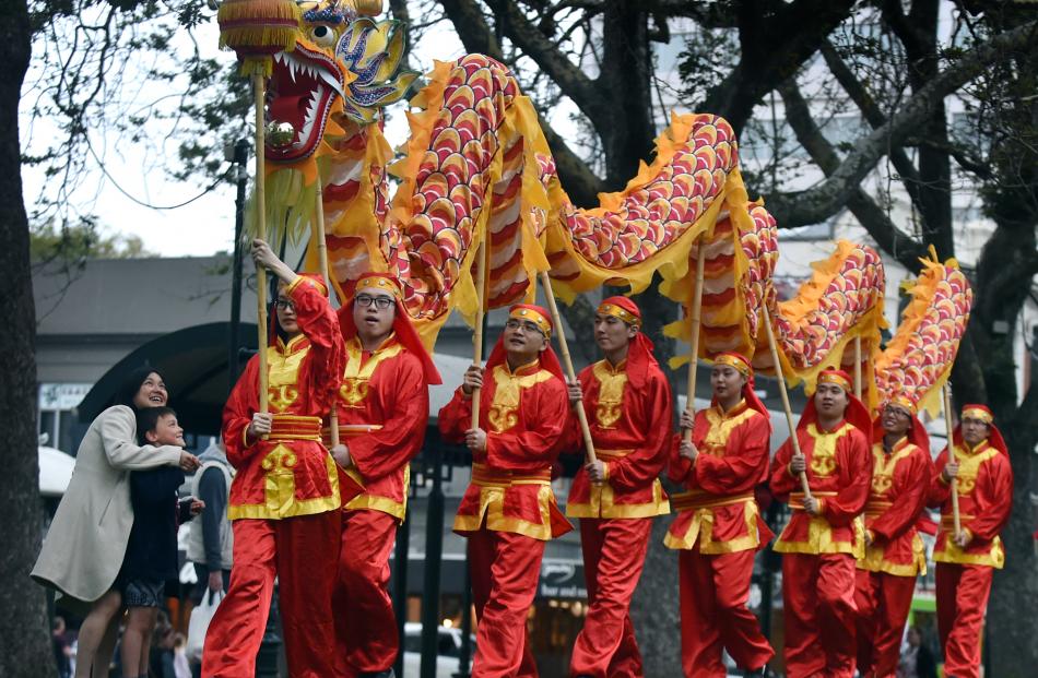 Chuan Lai and her son Edward Hager (7) watch the Dragon Dancing Team, led by University of Otago...