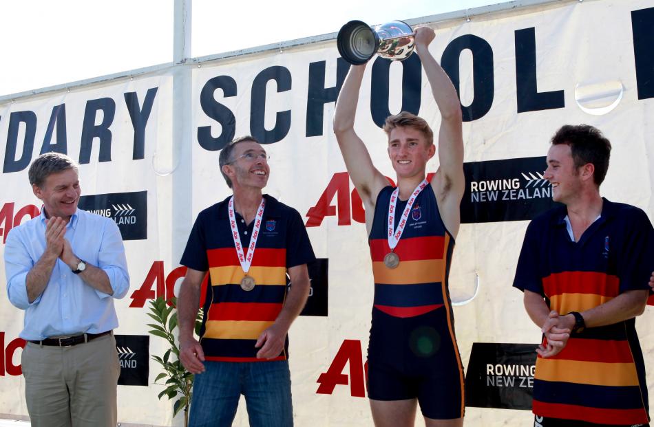 Bradley Leydon holds up the Charlie Stapp Trophy after winning the under-18 boys single sculls....