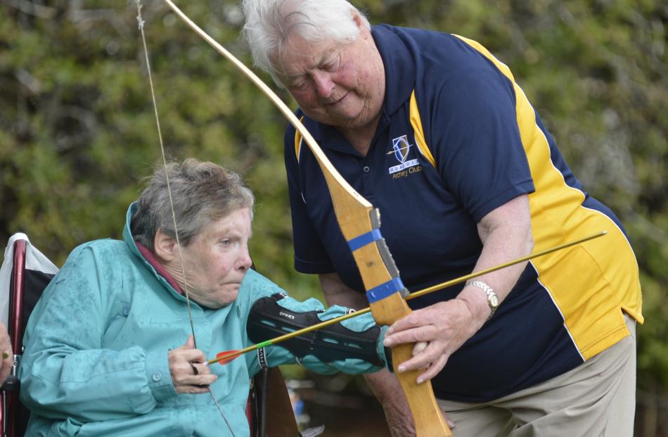 Dunedin Archery Club member Pam Gordon (right) helps Jill McRae, of Oamaru, try her hand at archery.