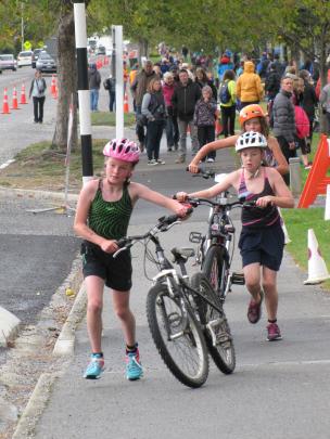 Competitors push their bikes to the beginning of the cyclying leg in the Otago Primary and...