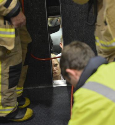 Libby Shepherd talks to firefighters as they work to free nine people trapped in an elevator between the 5th and 6th floors of the Burns Building in the Octagon. Photo: Gerard O'Brien