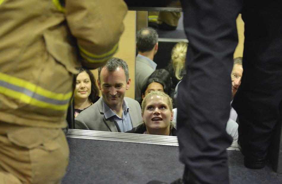 Libby Shepherd talks to firefighters as they work to free nine people trapped in an elevator between the 5th and 6th floors of the Burns Building in the Octagon. Photo: Gerard O'Brien