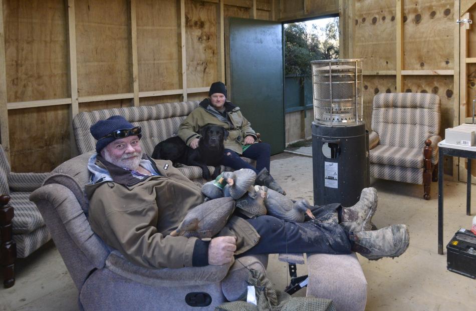 The Duncans and their dog Duke relax in their new mai mai. Photos: Gerard O'Brien.