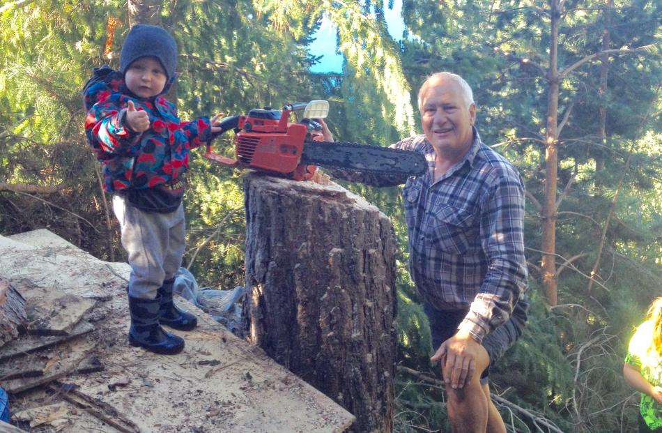 Archer Clark (2) shows his approval for his grandfather Peter Clark’s chainsaw handiwork after he...