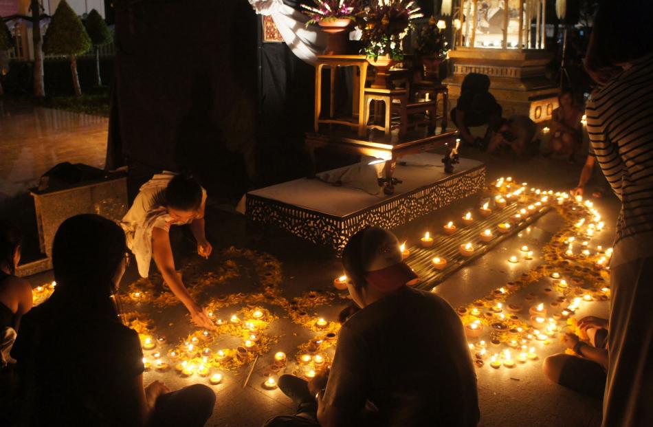 Families light candles in memory of Thailand’s late King Bhumibol Adulyadej at Chiang Mai’s Three...