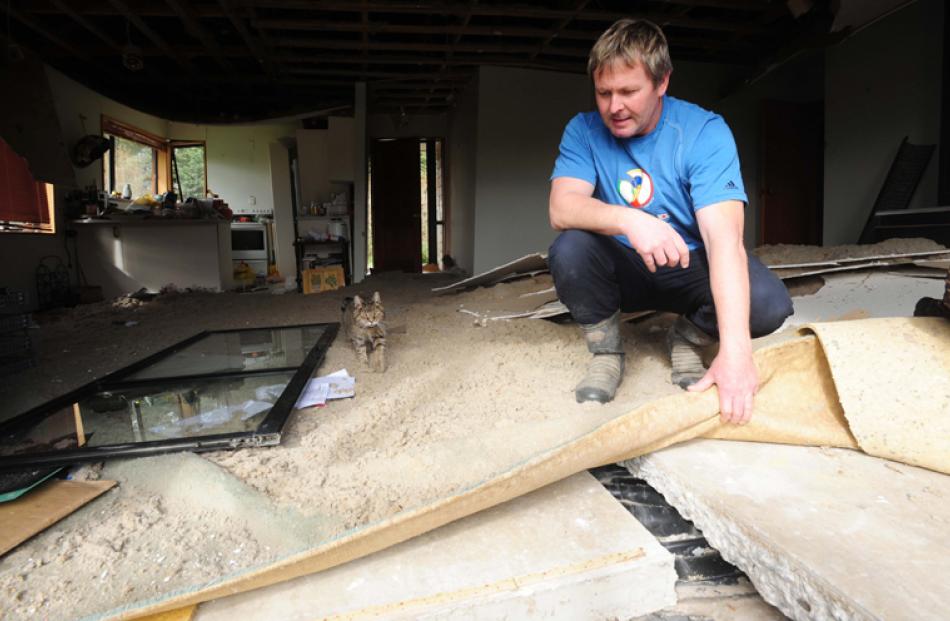 Craig Roberts inspects the snashed up concrete pad of his Kirwee house, which was split down the...