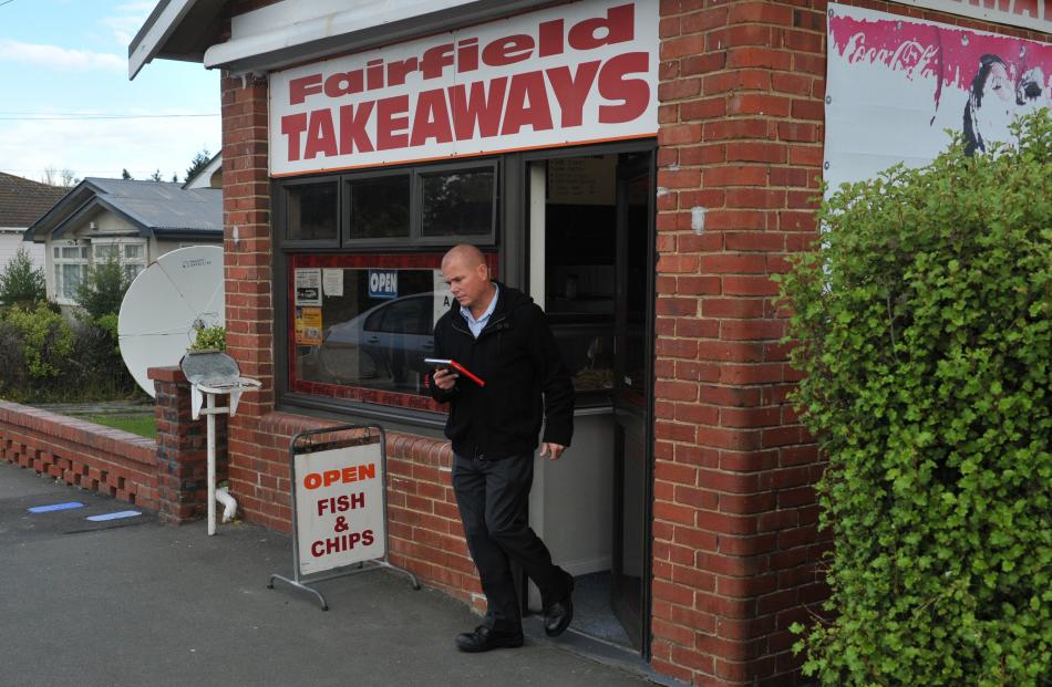 Police investigate the robbery of Fairfield Takeaways in January. PHOTO: STAFF PHOTOGRAPHER
