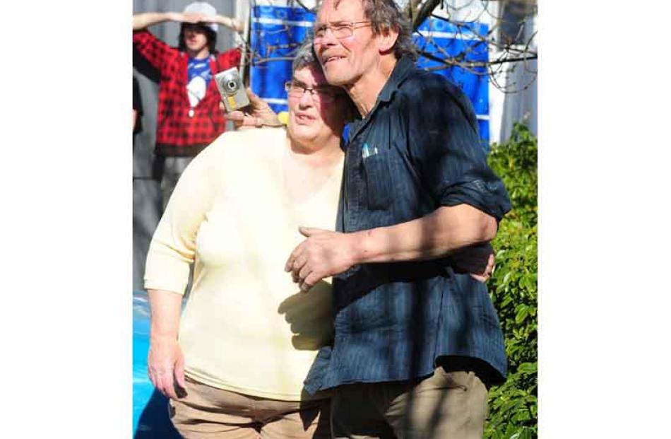 Lindsay and Nola Trott give each other a hug as they watch the building where they ran their...