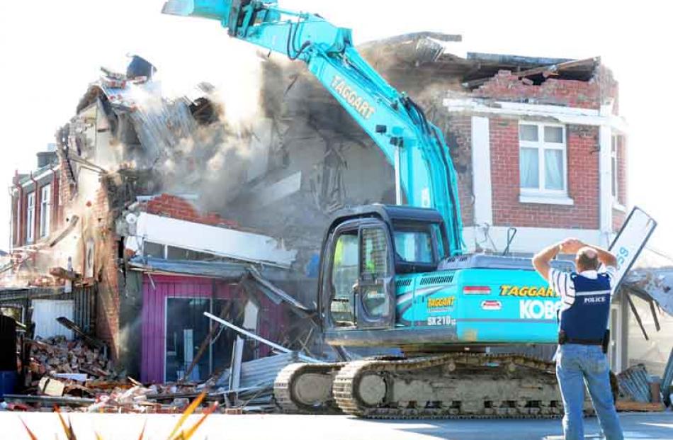 A ditchdigger demolishes a row of shops in St Albans, Christchurch, after an aftershock...