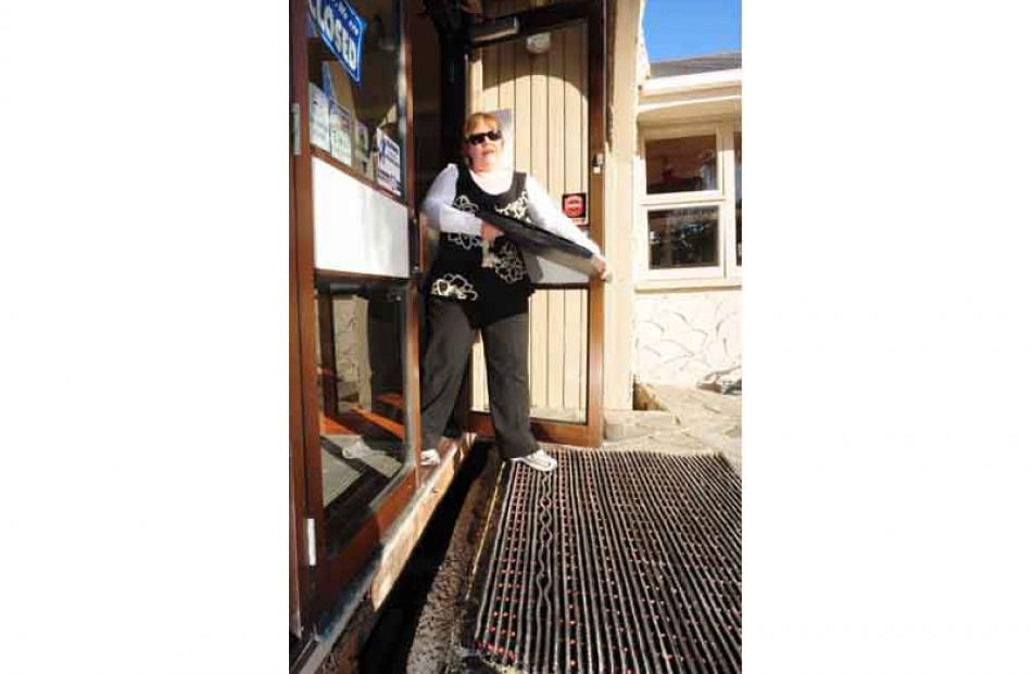 Debbie Riley steps over a new 30cm gap that her resturant has moved as she removes some of the...