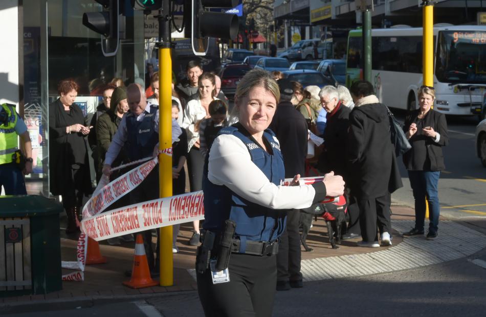 Police officers set up a cordon at the intersection of George St and Moray Pl, one of many to go up after the discovery of a suspicious package. Photo: Gregor Richardson