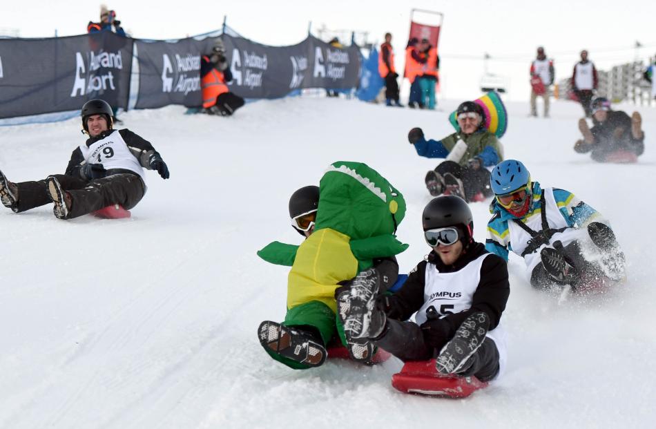 Dinosaur Julien Facci, of Queenstown and Mitchell Rawson, of Australia, are neck and neck in the bobsleigh race at Coronet Peak on Saturday, while Queenstown local Corey Sinteur dressed as a Mexican is in the rear. Photos: Stephen Jaquiery