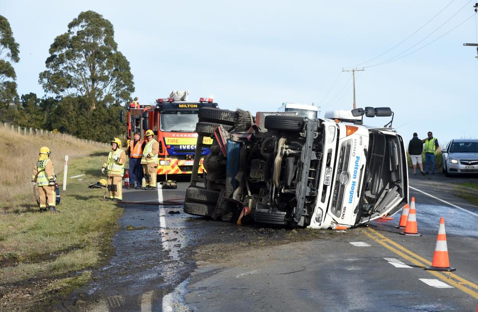 Firefighters clean a section of State Highway 1 in the wake of the crash.