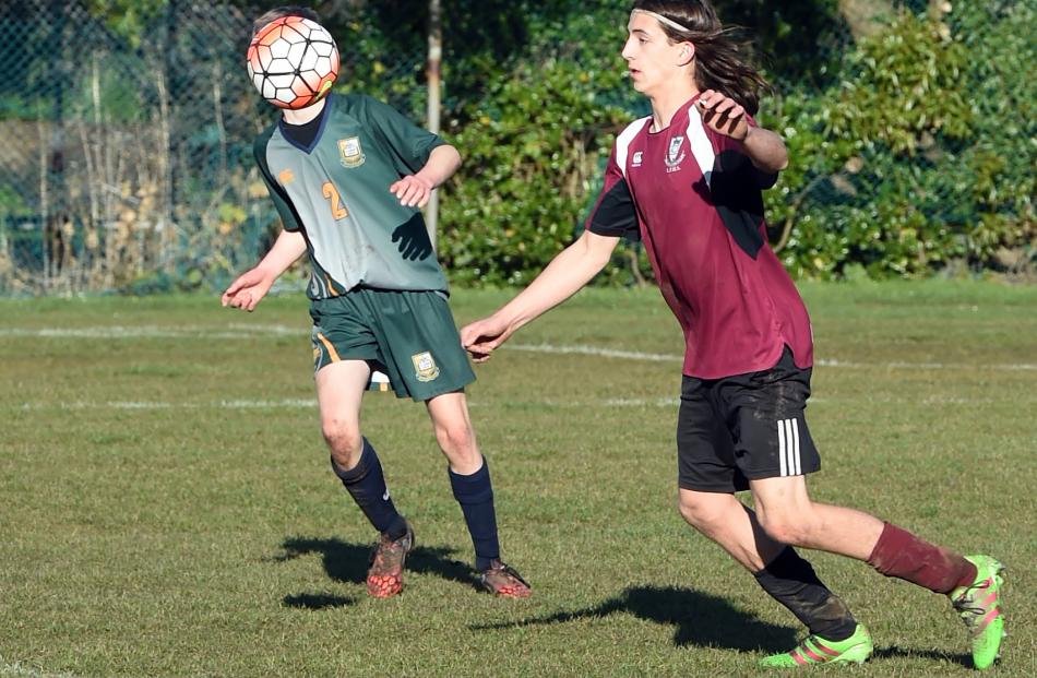 Logan Park High School’s Benjamin Dubyk (17) looks to control the ball while Finn Cattaway (15) ...