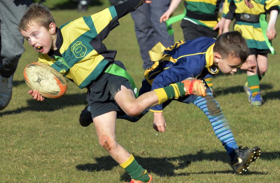 Mason Bond (6), of Green Island Black (above left), dodges the tackle of Robbie McPherson (6), of Dunedin Mako Sharks, in an under-7 division match.