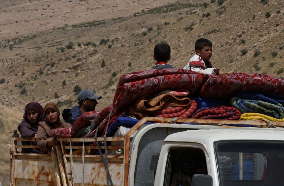Syrian refugees on the back of a truck at Lebanon's border region of Arsal last week. Photos: Reuters